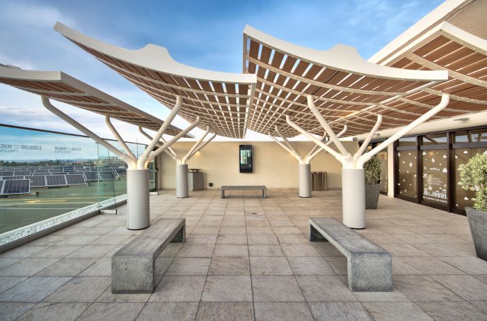 Several wooden canopies providing shade on an airport observation deck
